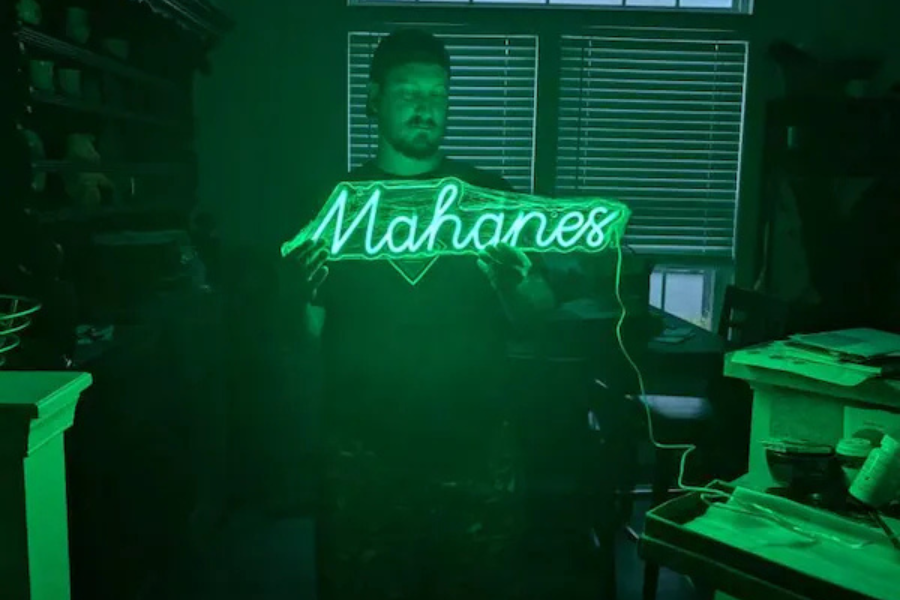 Green neon business logo sign in a workshop